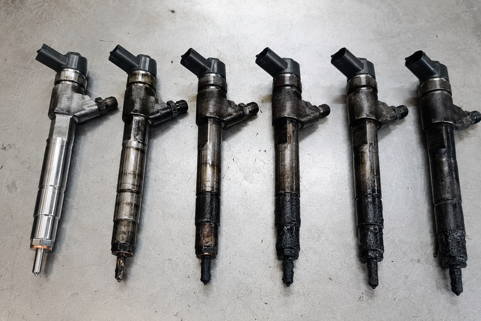 Jaguar AJD-V6 injectors showing heavy carbon buildup on tips from failed injector seals